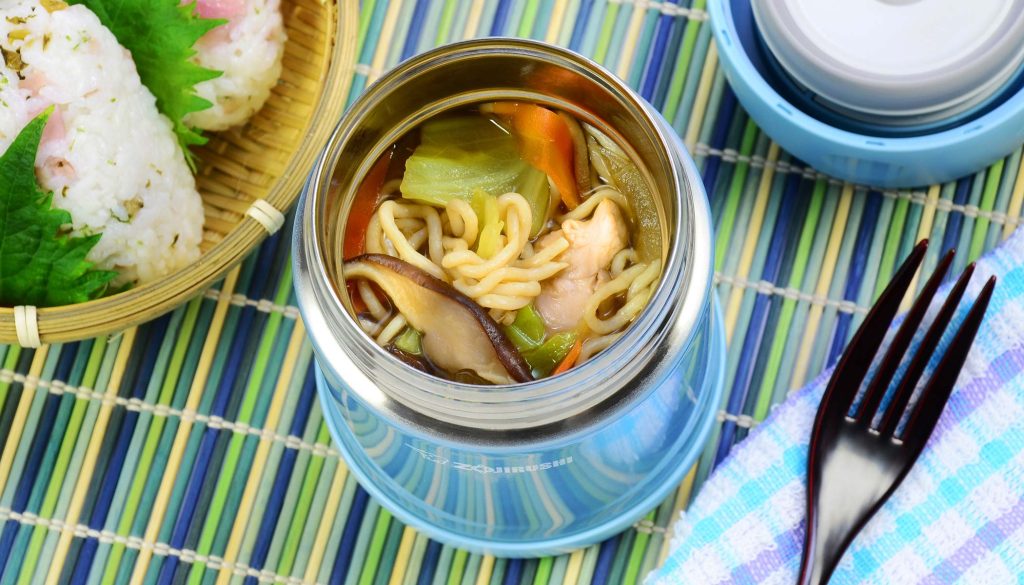 Lunch with a light blue food jar filled with ramen noodle soup and a side of onigiri