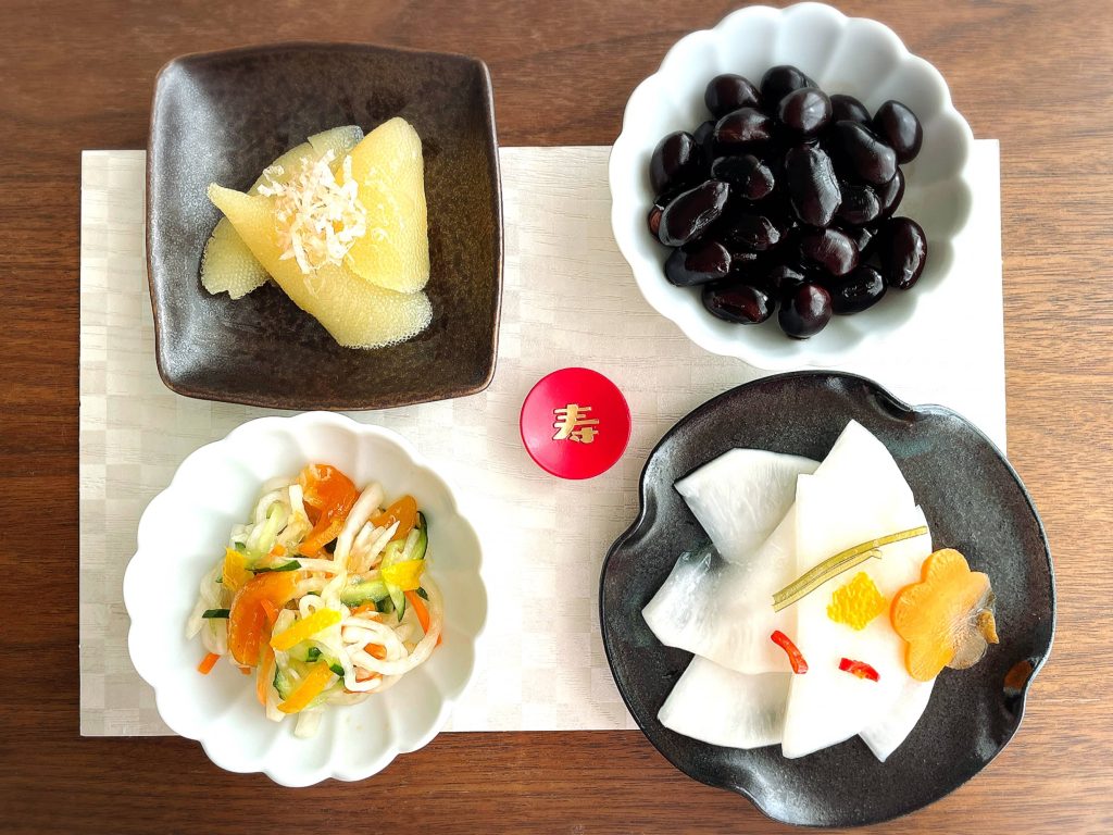 Top view of four plate filled with various side dishes and pickles