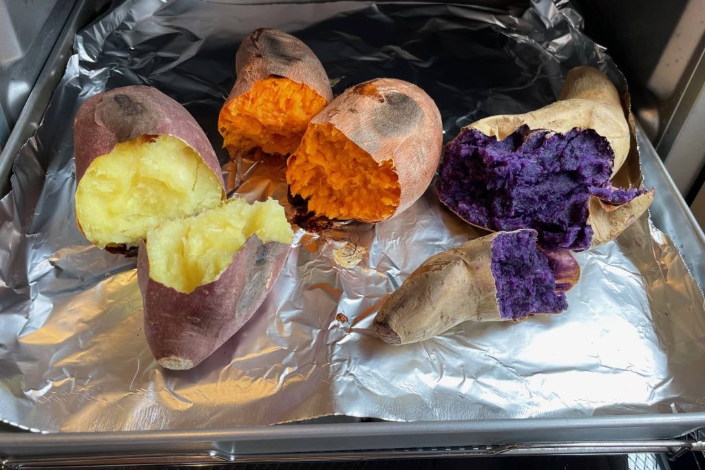 Three colors of sweet potato on a pan coming out of toaster oven