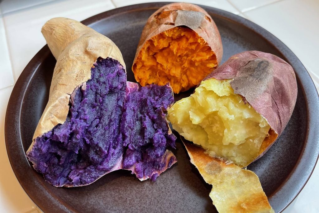 Close-up of three sweet potatoes: purple, orange and yellow