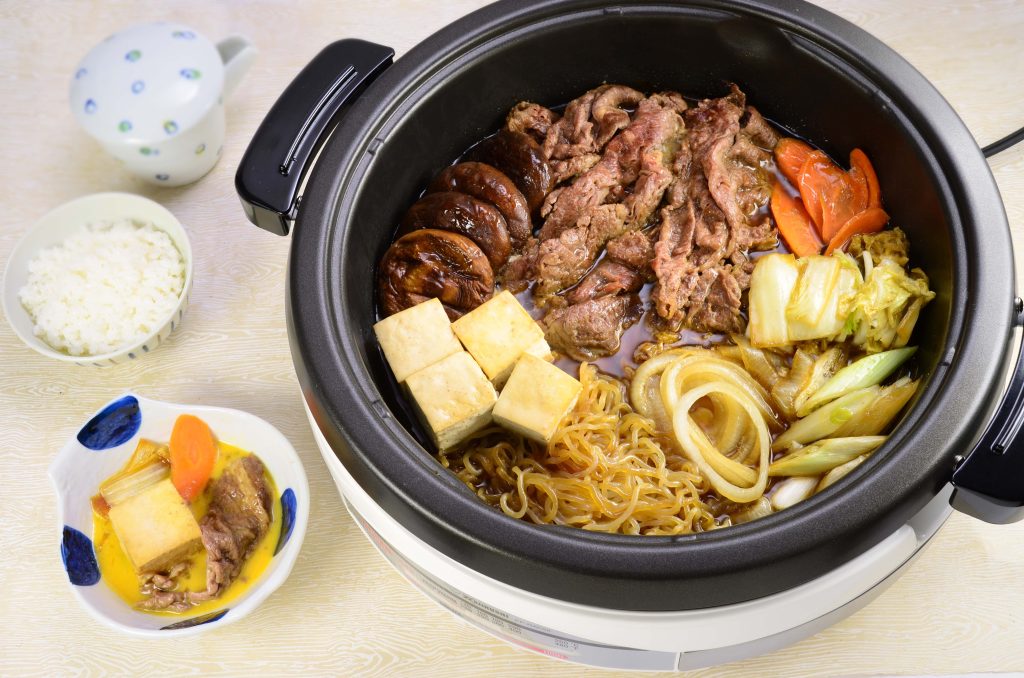 Electric skillet with stew of meat, tofu, carrots, leeks and shirataki noodles