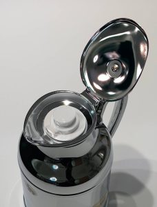 Top view of a chrome carafe has the upper lid open allowing to see the actual lid.