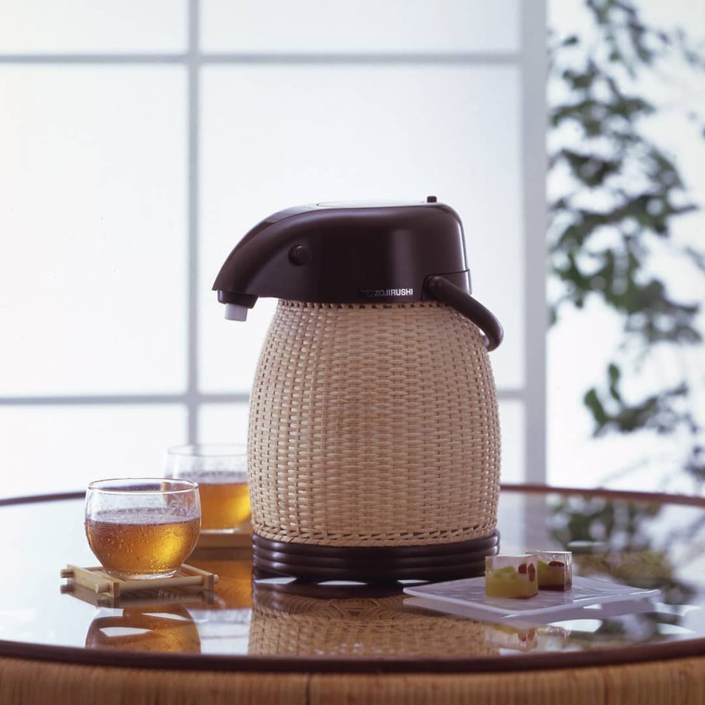 Glass table with an Air Pot from the rattan line with two cups of tea next to it