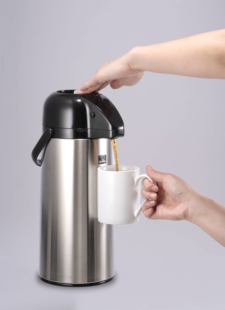 Beverage dispenser being used by pressing the top button and serving a cup of coffee