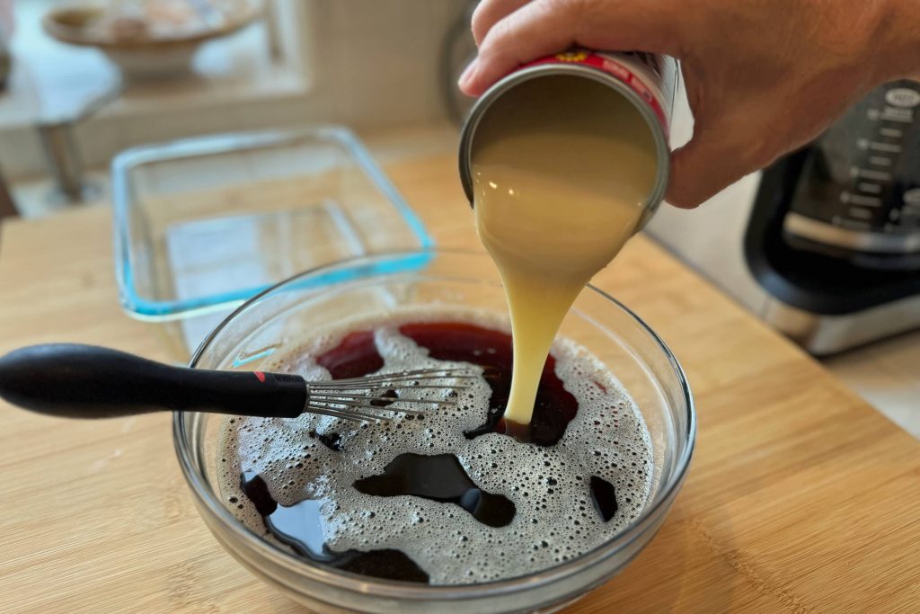 pouring condensed milk into jello mixture