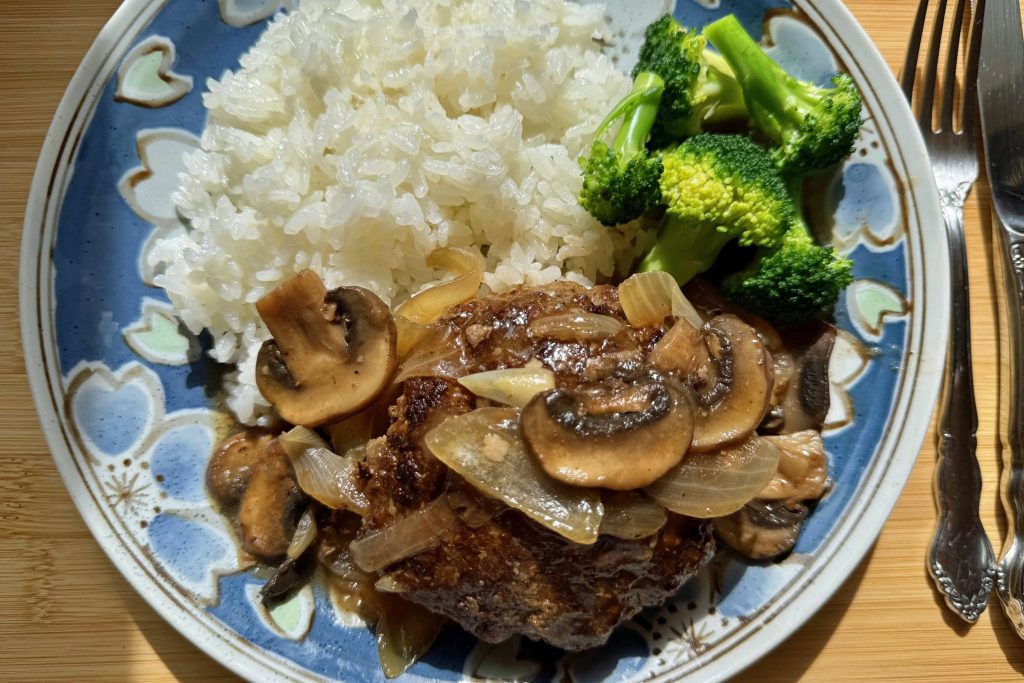 Salisbury steak served with broccoli and rice