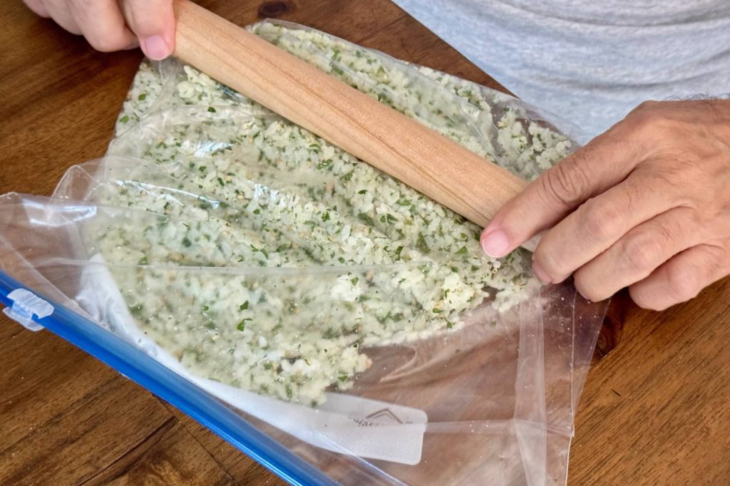 Preparing rice crackers by flattening rice