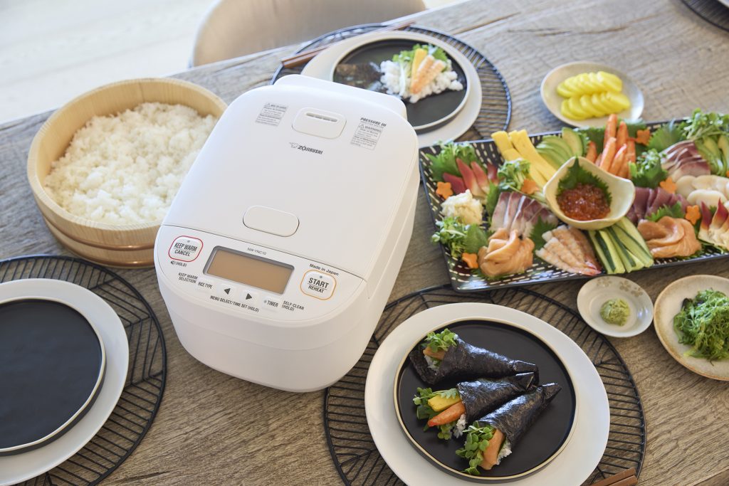 Sushi spread on a table with a Zojirushi rice cooker
