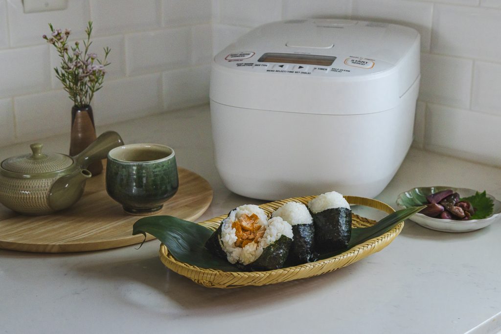 salmon onigiri with tea, rice cooker in the back