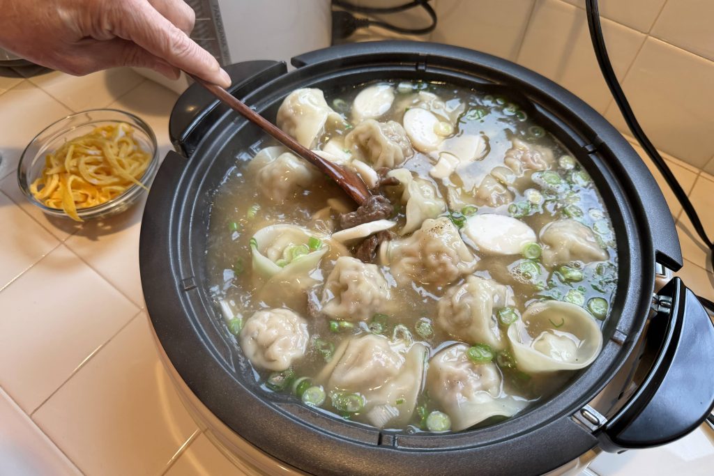 Korean dumpling soup shown in skillet
