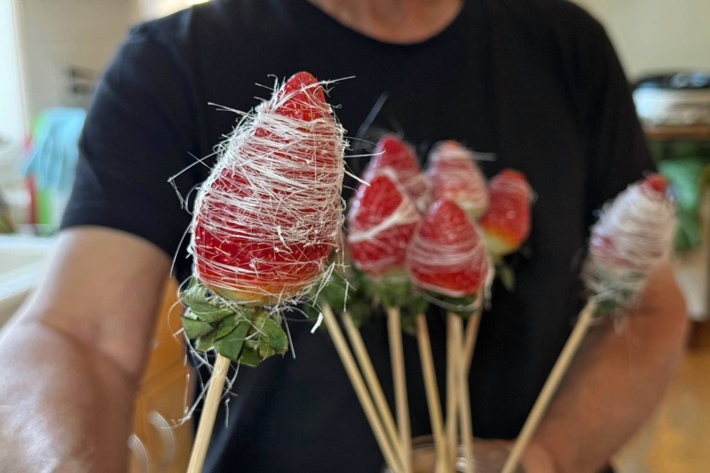 holding marshmallow strawberries