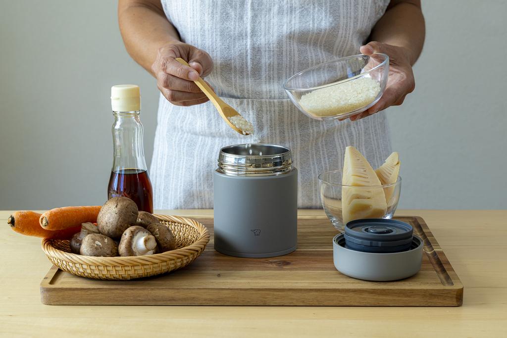 Pouring uncooked rice into the grey food jar