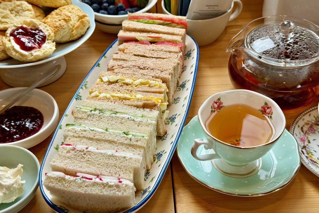 afternoon tea showing sandwiches, scones and tea