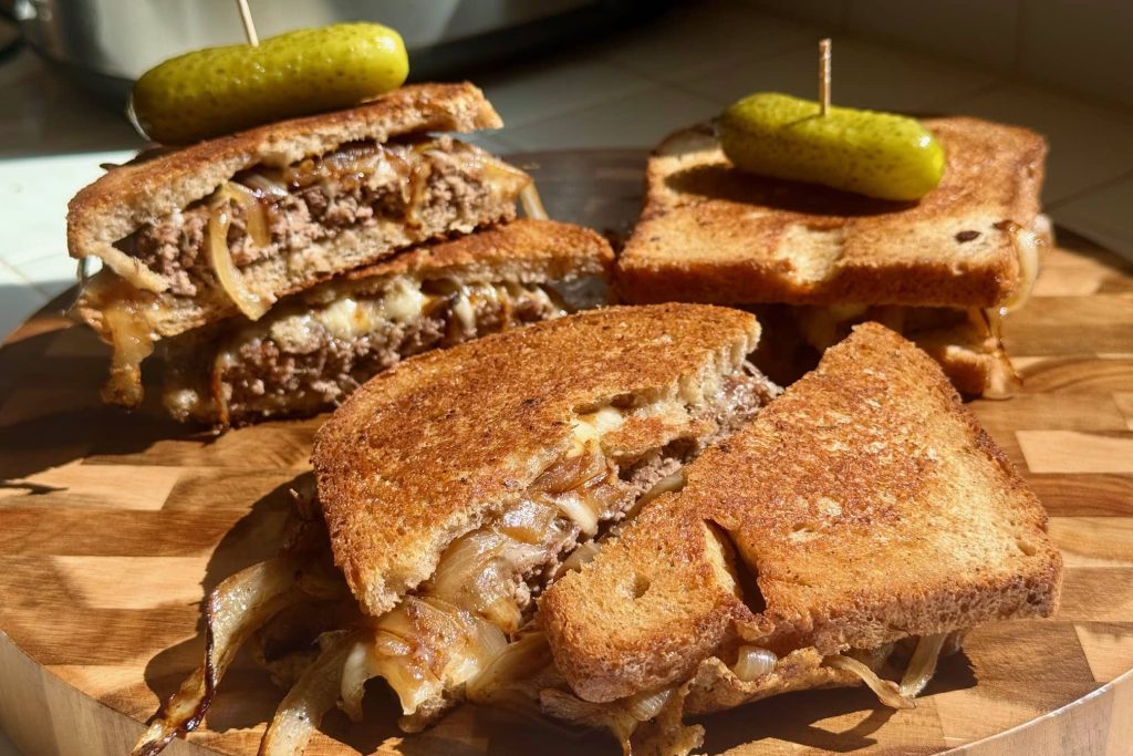 patty melt sandwiches shown with pickle speared on top
