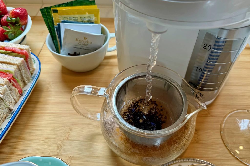 hot water from water boiler pouring into tea carafe