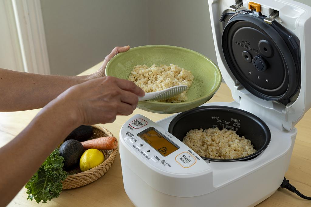 pouring brown rice from rice cooker