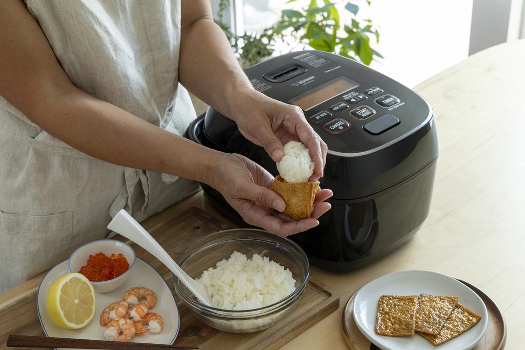 Stuffing rice in Inari next to the rice cooker