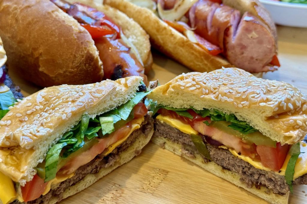 Smash burgers cross section, Polish sausages in background