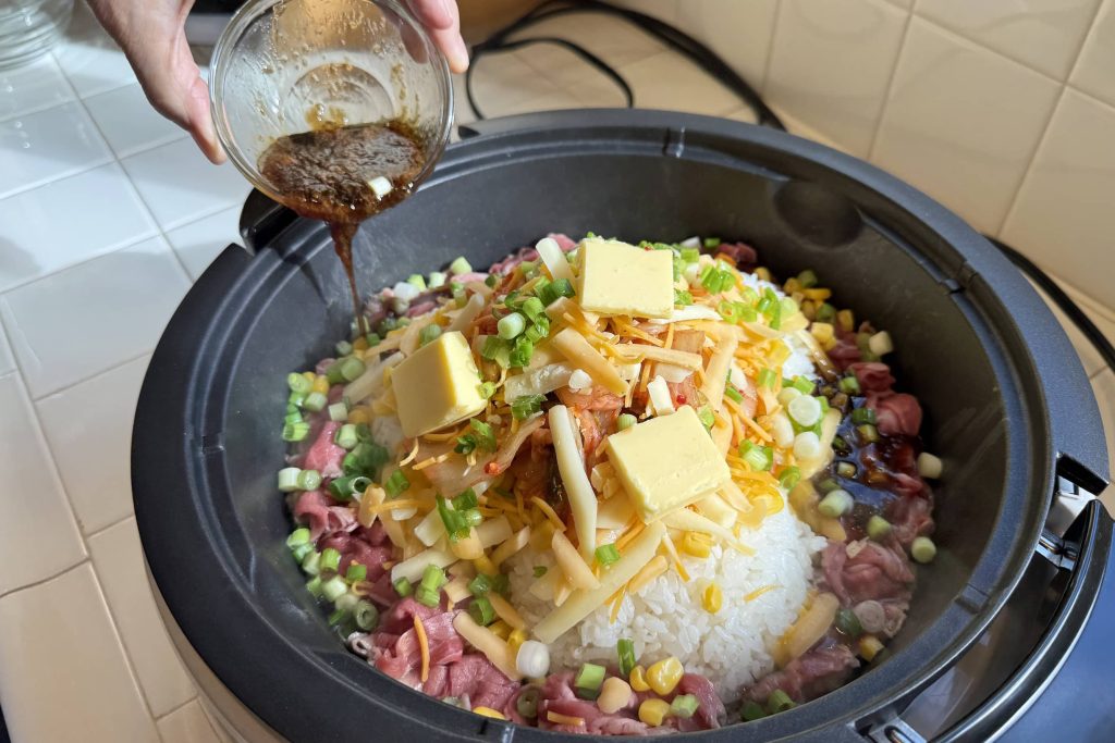 pouring sauce into the griddle of Pepper Rice ingredients
