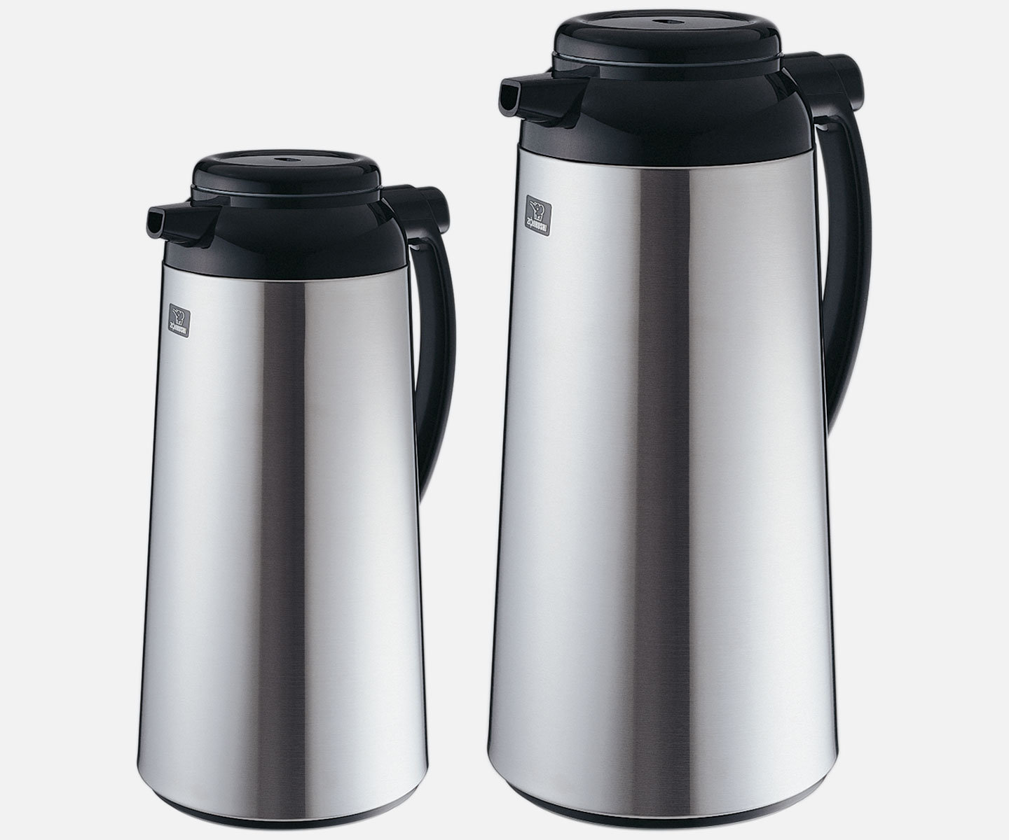 Two stainless steel carafes with black lids, one smaller on the left and a larger one on the right.